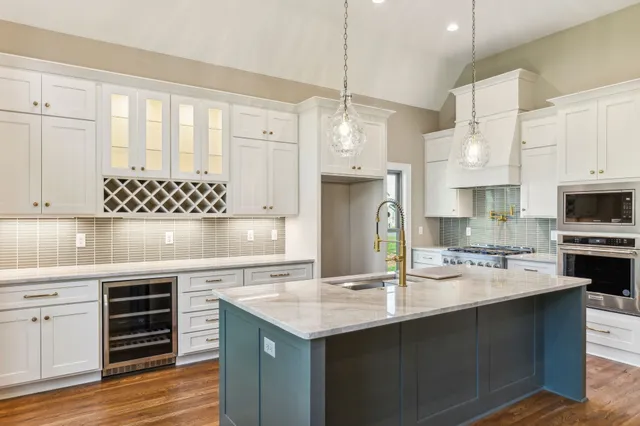 a kitchen with stainless steel appliances granite countertop a sink refrigerator and cabinets