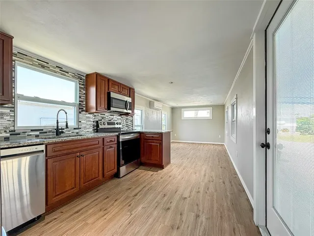 a large kitchen with wooden floors and wooden cabinets