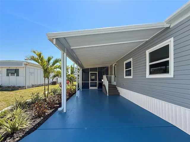 a view of a house with backyard and sitting area