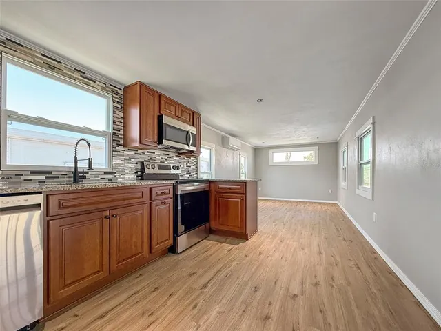 a kitchen with stainless steel appliances granite countertop a sink cabinets and wooden floor