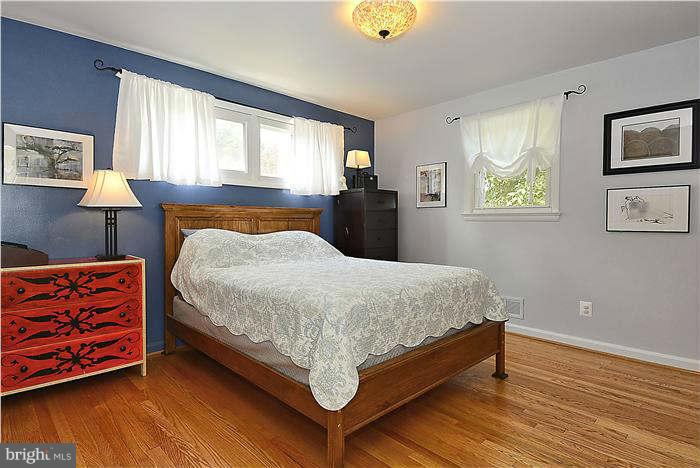 10204 Portland Road Silver Spring, MD 20901 - Photo 14 of 29 a bedroom with a bed and wooden floor
