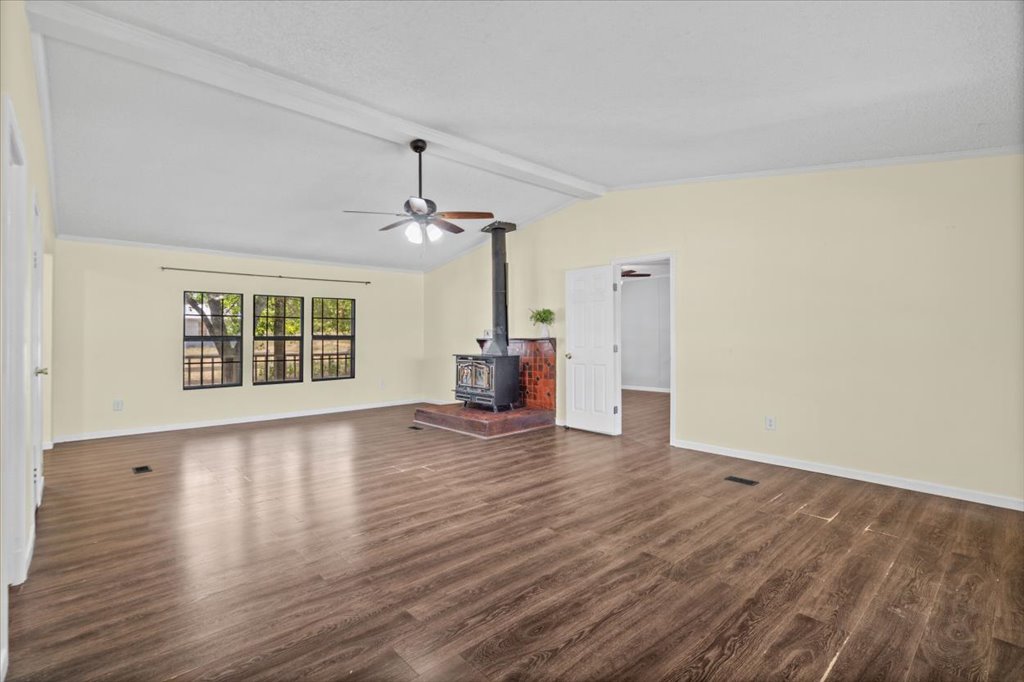 13501 Nutty Brown Road, Unit B Austin, TX 78737 - Photo 8 of 29 A spacious living area features a wood-burning stove, creating a cozy and inviting atmosphere.