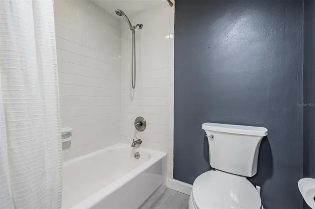 a white toilet sitting next to a bath tub