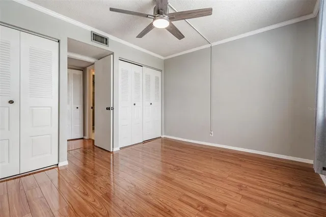 a view of an empty room with wooden floor