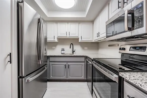 a kitchen with stainless steel appliances granite countertop a sink stove and refrigerator