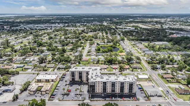 a view of a brick house with many windows and a tree