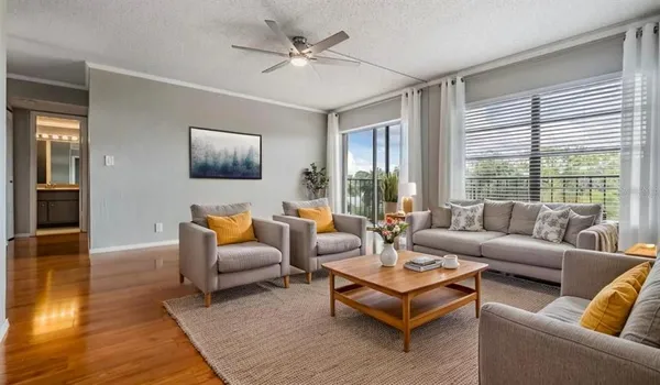 a living room with furniture flat screen tv and a large window