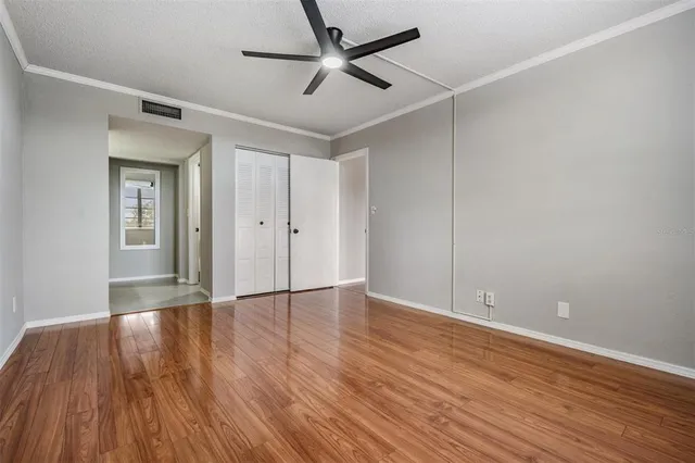 an empty room with wooden floor and windows