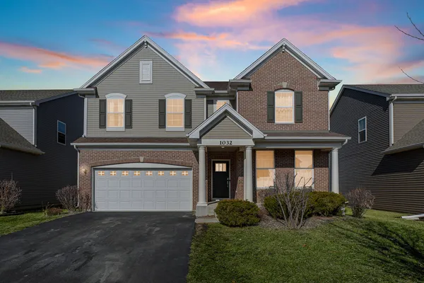 a front view of a house with a yard and garage