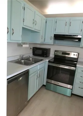 a kitchen with granite countertop white cabinets and stainless steel appliances