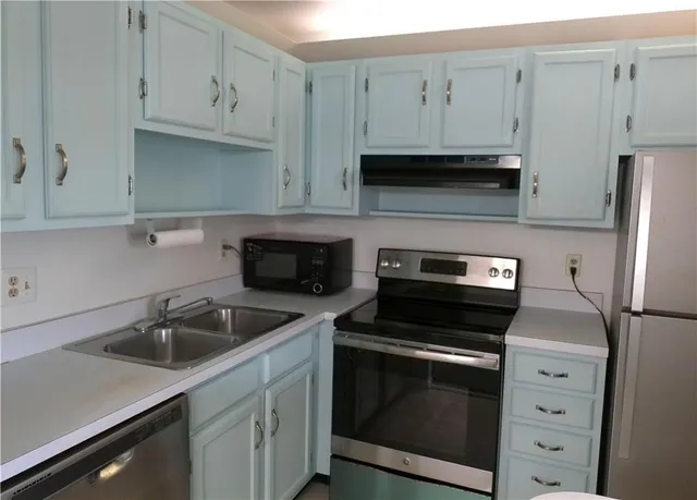 a kitchen with white cabinets and stainless steel appliances