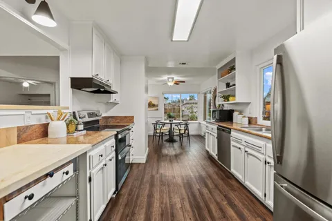 a kitchen with appliances cabinets and a wooden floor