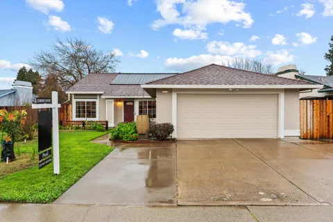 a front view of a house with a yard and potted plants