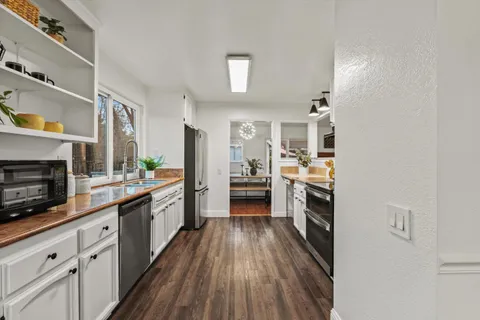 a dining room with furniture a chandelier and wooden floor