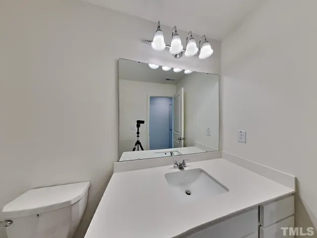 a bathroom with a sink a toilet and a mirror