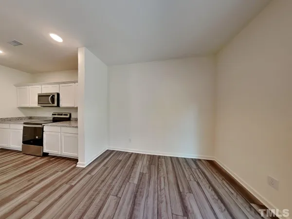 a view of kitchen with wooden floor and electronic appliances