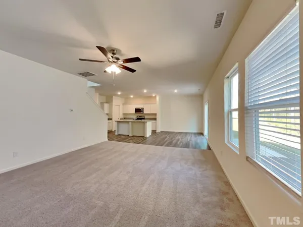 a view of an empty room with a ceiling fan and window