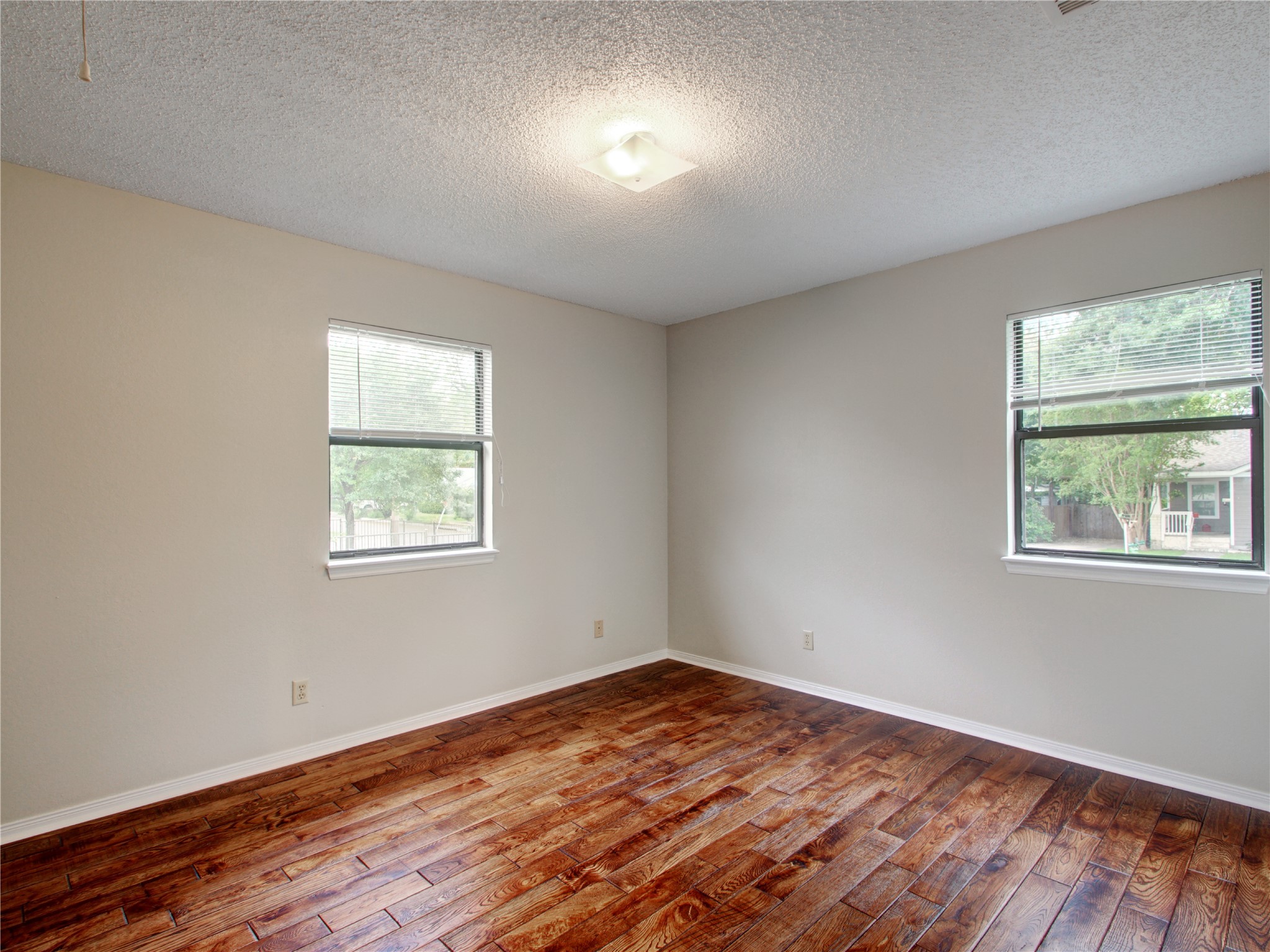 4703 Rosedale Avenue, Unit A Austin, TX 78756 - Photo 12 of 19 Unfurnished room with dark wood-style floors, a textured ceiling, and healthy amount of natural light