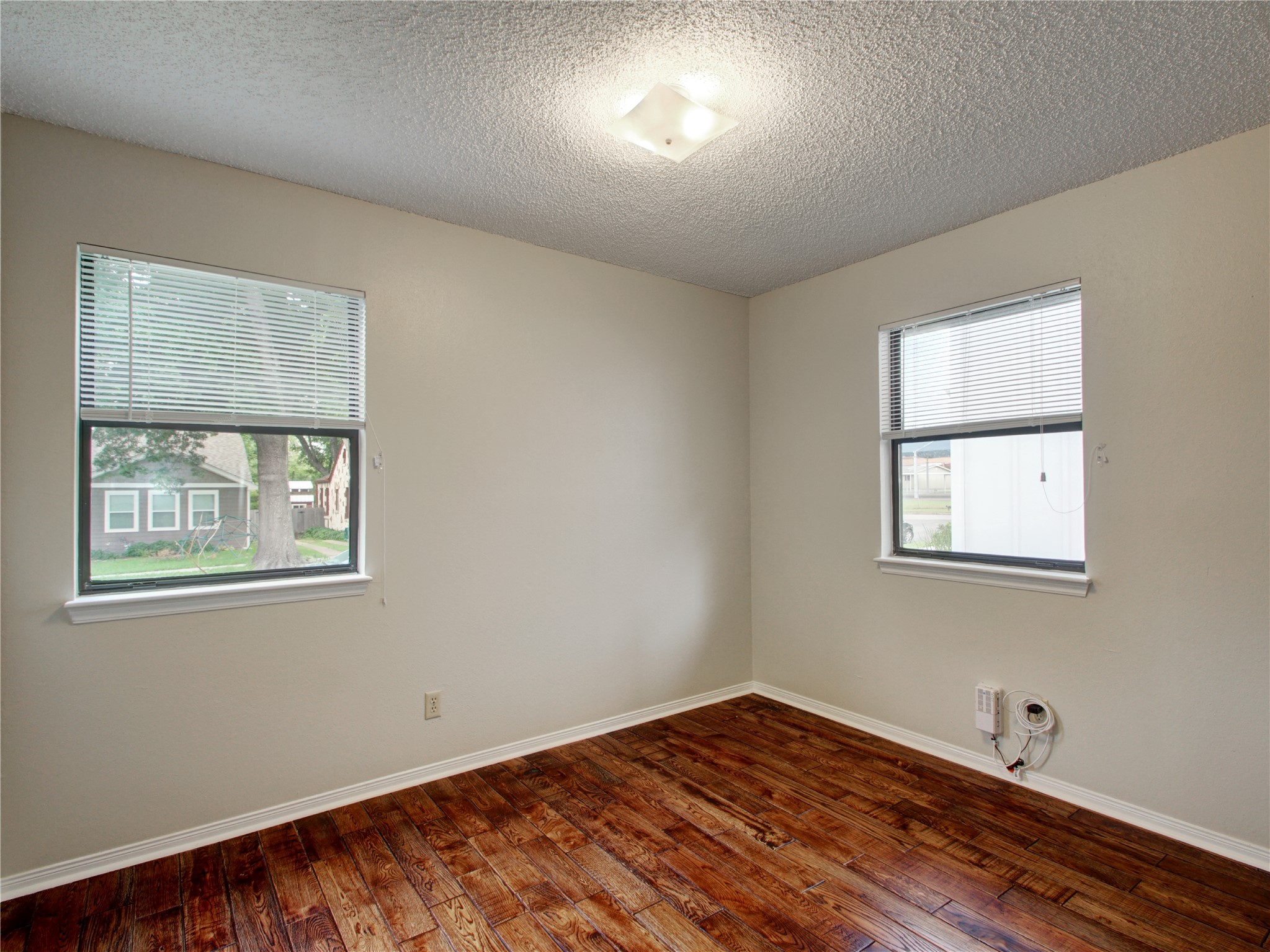 4703 Rosedale Avenue, Unit A Austin, TX 78756 - Photo 9 of 19 Empty room featuring dark wood-style floors and a textured ceiling