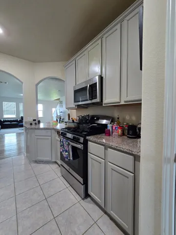 a kitchen with stainless steel appliances granite countertop a stove a sink and a microwave