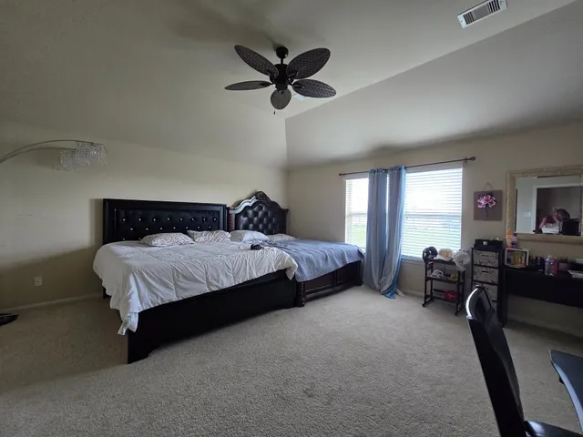 a bedroom with a bed couch and a large window