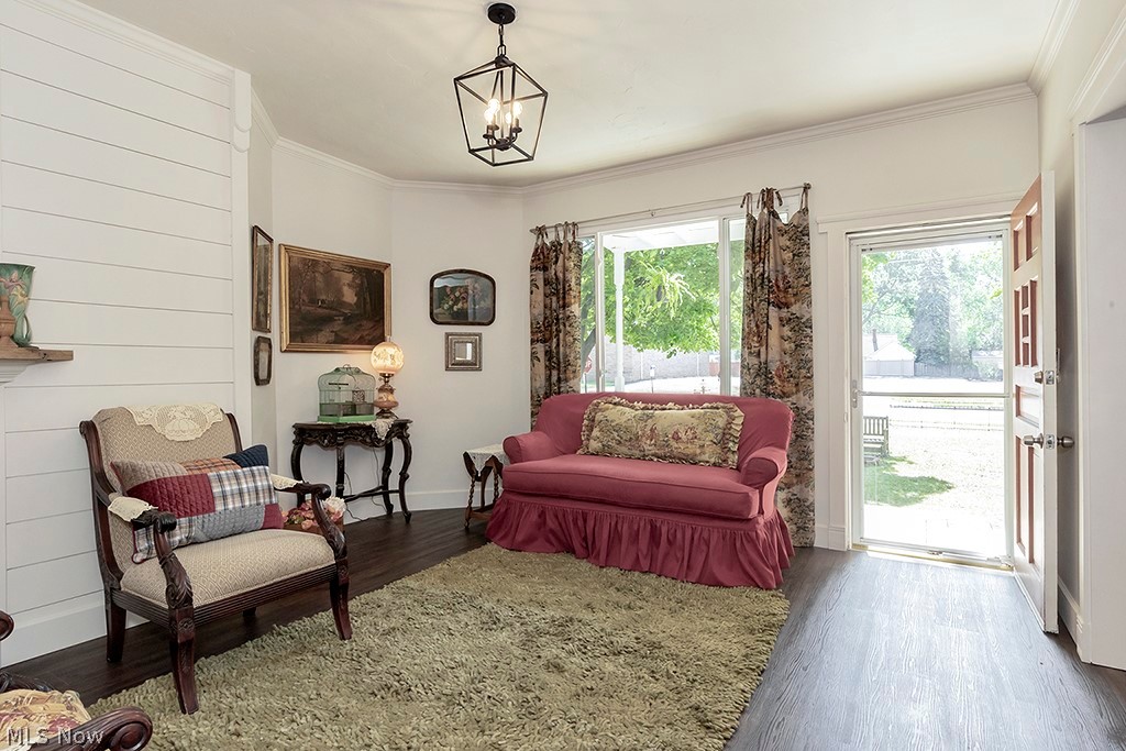 Sitting room featuring ornamental molding, dark hardwood / wood-style floors, and a notable chandelier