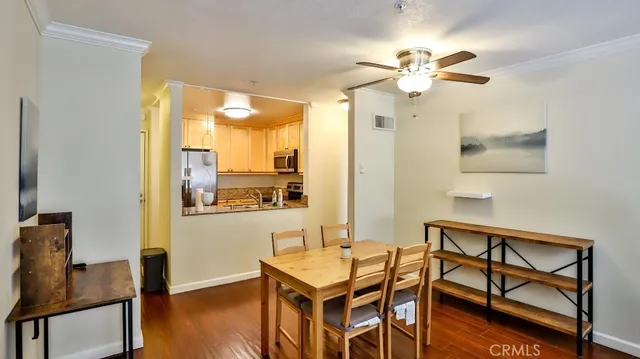 a room with a table and a chandelier fan