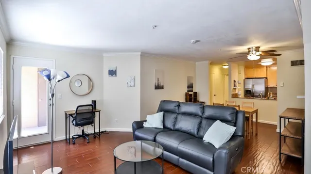 a living room with furniture a table and wooden floor