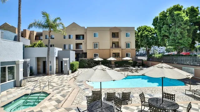 a view of a patio with chairs and table under an umbrella