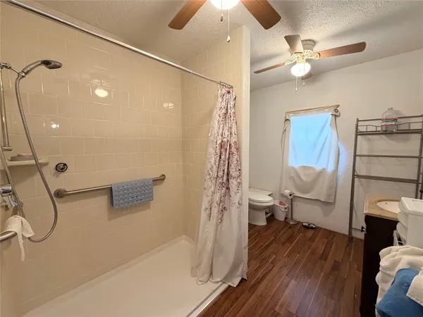 a bathroom with a sink a toilet and shower