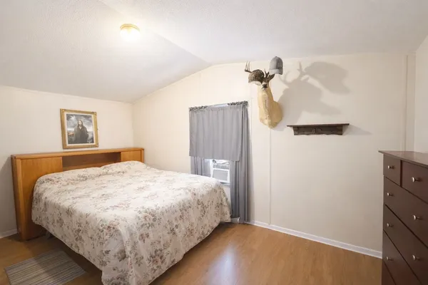 a bedroom with a bed and a painting on the wall