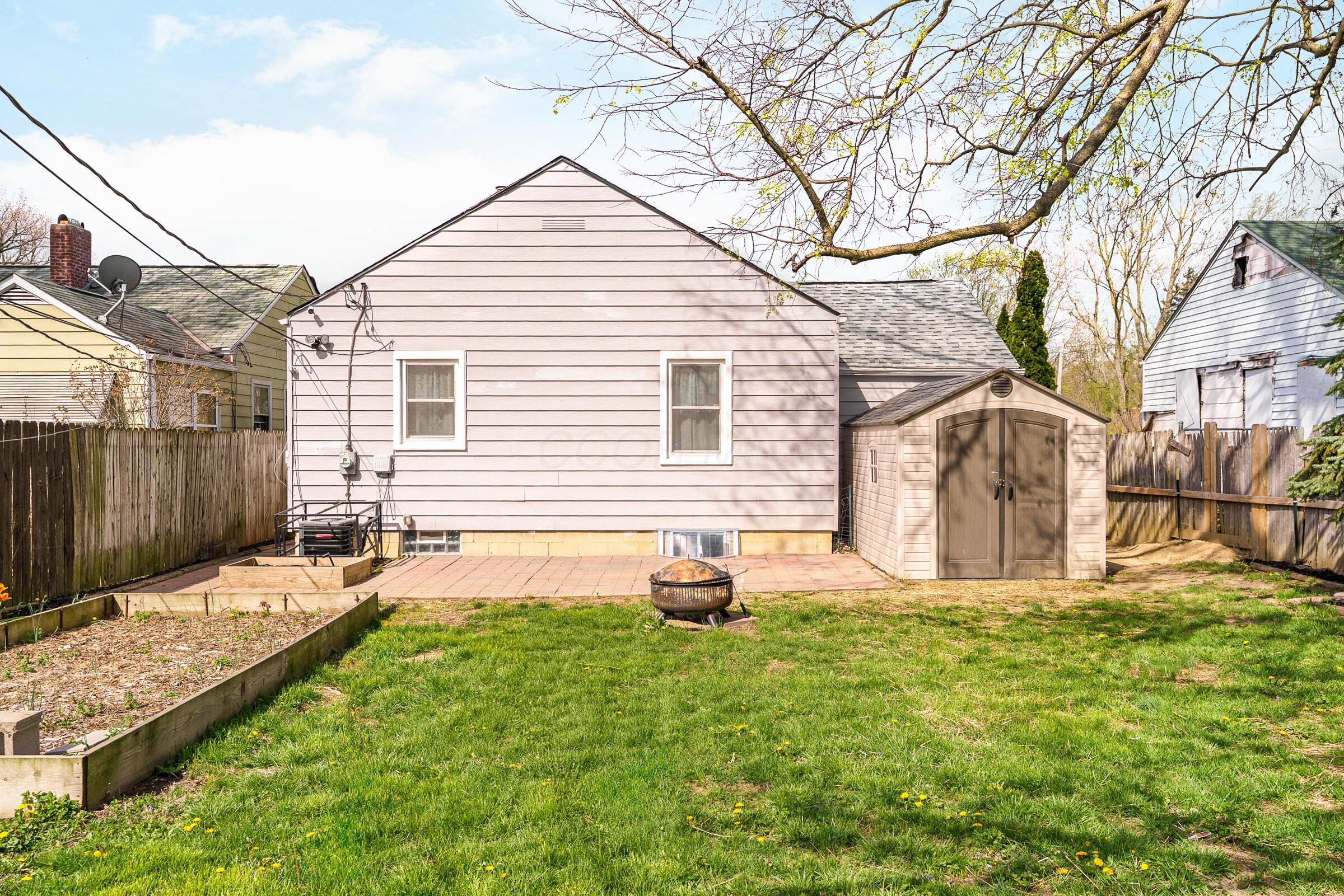 2780 Audubon Road Columbus, OH 43211 - Photo 28 of 32 Exterior back of the home featuring a shed, patio, raised garden bed and a firepit.