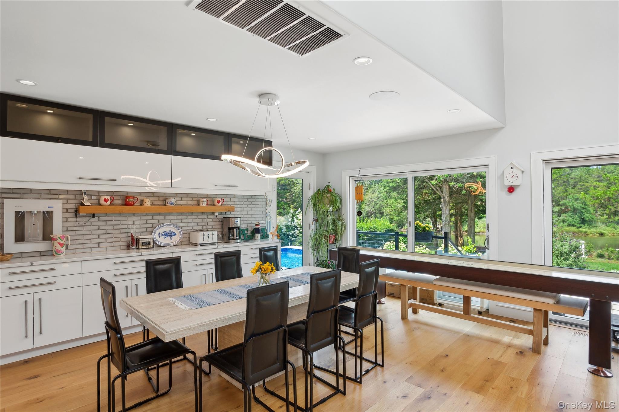 425 Cedar Point Drive East Southold, NY 11971 - Photo 11 of 47 a kitchen with stainless steel appliances kitchen island granite countertop a table and chairs in it