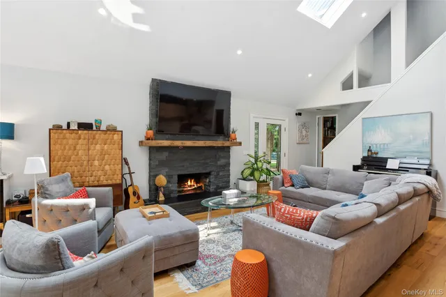 a living room with furniture kitchen view and a large window