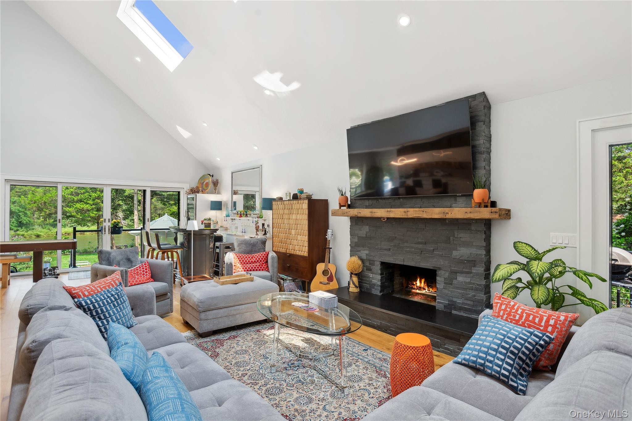 425 Cedar Point Drive East Southold, NY 11971 - Photo 17 of 47 a living room with furniture large window and a fireplace