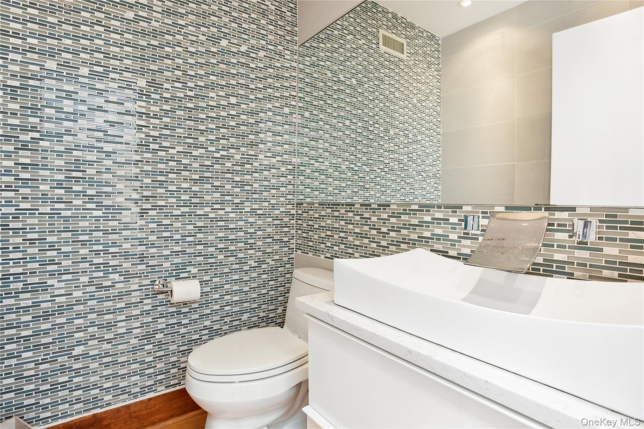 425 Cedar Point Drive East Southold, NY 11971 - Photo 19 of 47 a bathroom with a sink a toilet and a mirror