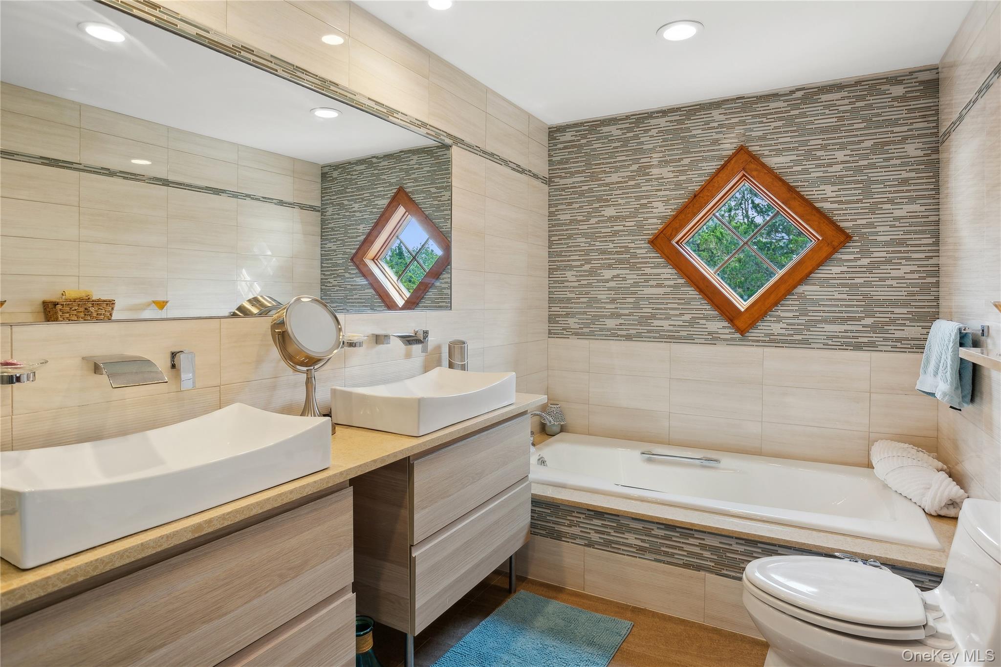 425 Cedar Point Drive East Southold, NY 11971 - Photo 28 of 47 a bathroom with a sink a mirror and a bathtub