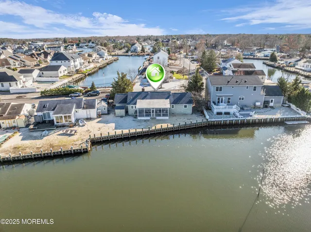 an aerial view of residential houses with outdoor space and ocean view