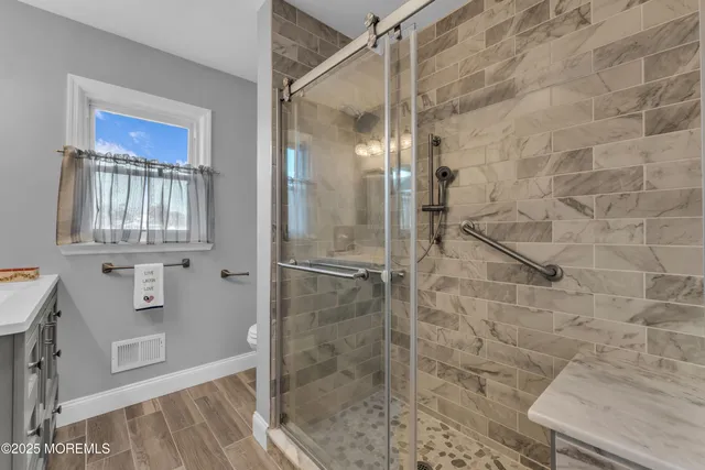 a bathroom with a granite countertop sink a toilet and shower