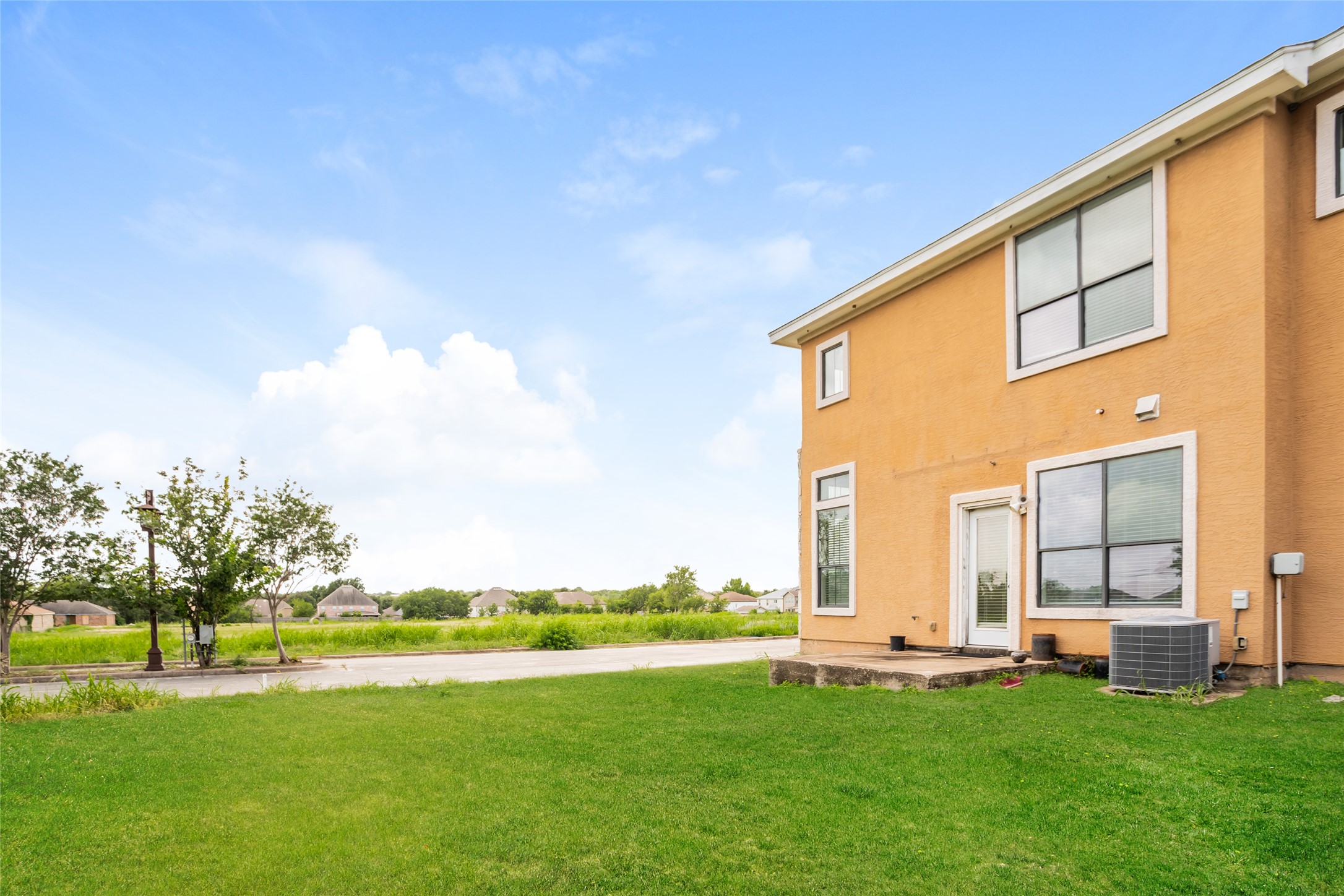 1010 Immanuel Road, Unit 128 Pflugerville, TX 78660 - Photo 14 of 17 A private yard with a concrete patio offers peaceful outdoor living beside a modern multi-story dwelling.