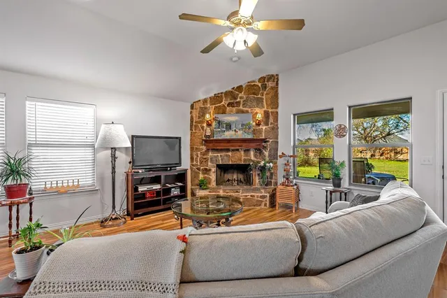 a living room with furniture kitchen view and a chandelier