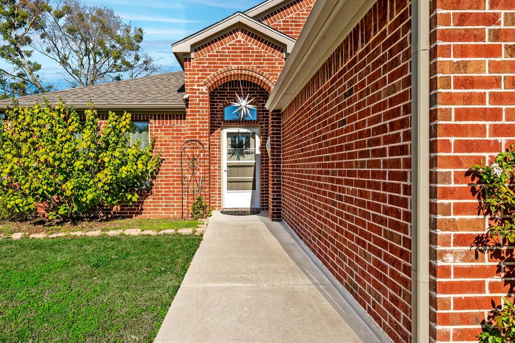 1209 Sherman Street Tioga, TX 76271 - Photo 9 of 40 a view of a brick house with a yard