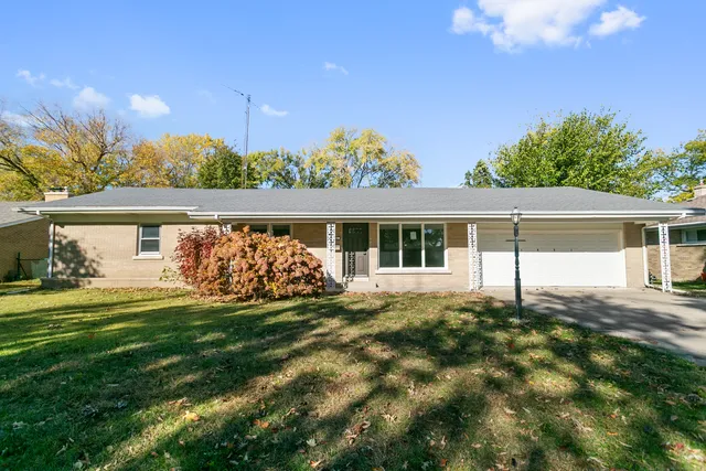 a view of a house with a yard and sitting area