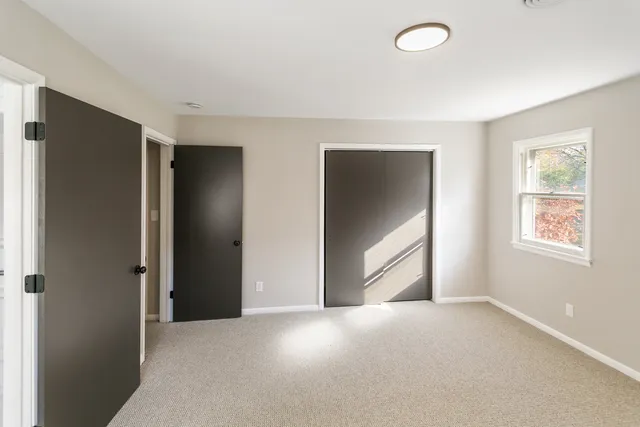 an empty room with windows and closet