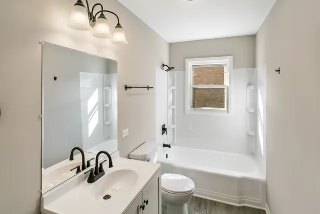 a bathroom with a sink mirror toilet and bathtub