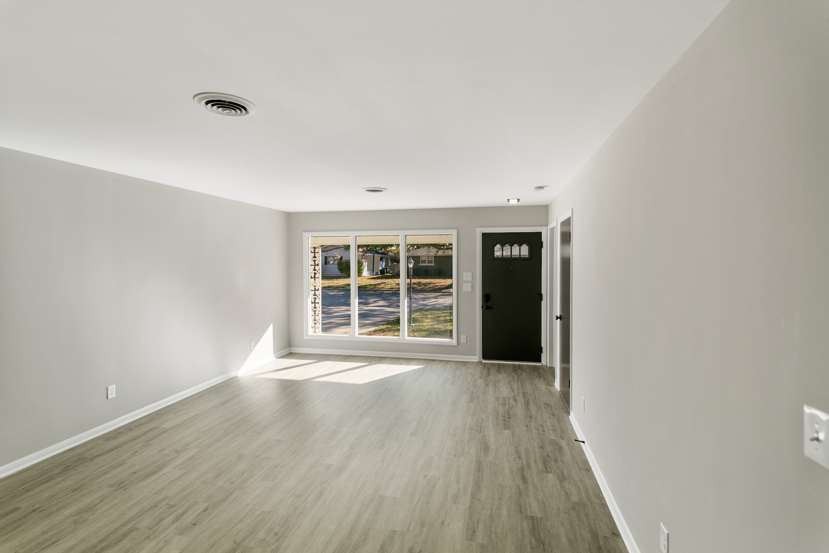 1431 West Vanmeter Street Kankakee, IL 60901 - Photo 4 of 19 a view of an empty room with wooden floor and a window