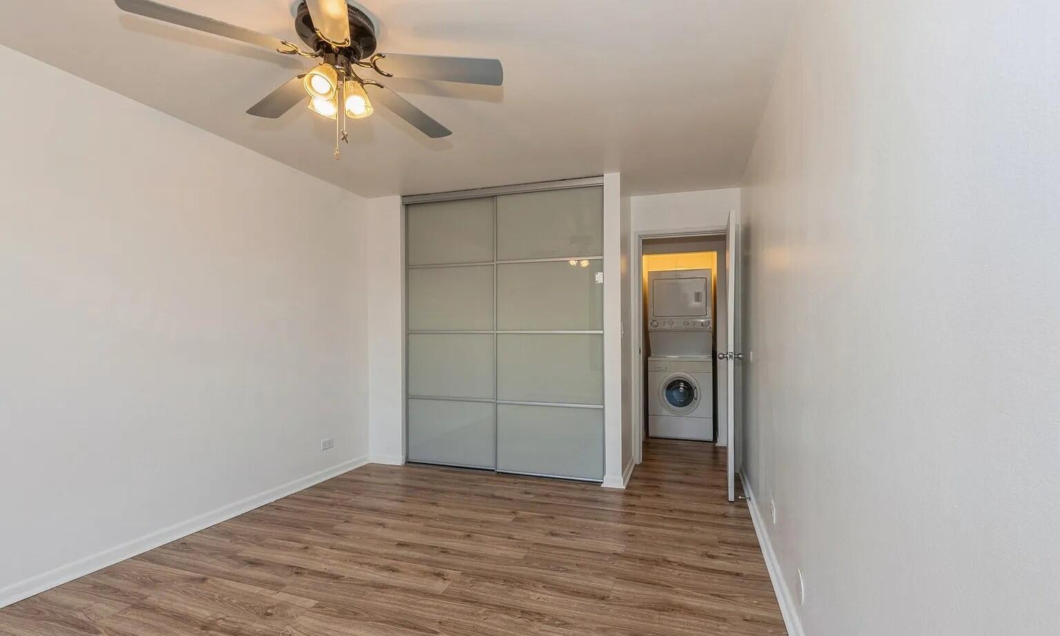 3900 North Pine Grove Avenue, Unit 405 Chicago, IL 60613 - Photo 11 of 15 a view of empty room with wooden floor and fan