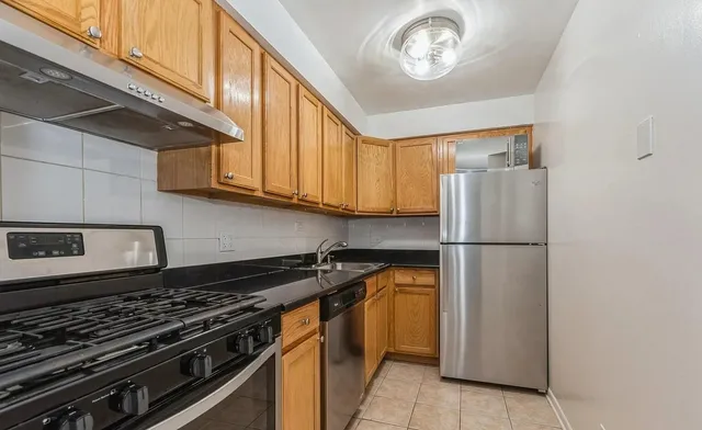 a kitchen with a refrigerator and a stove top oven