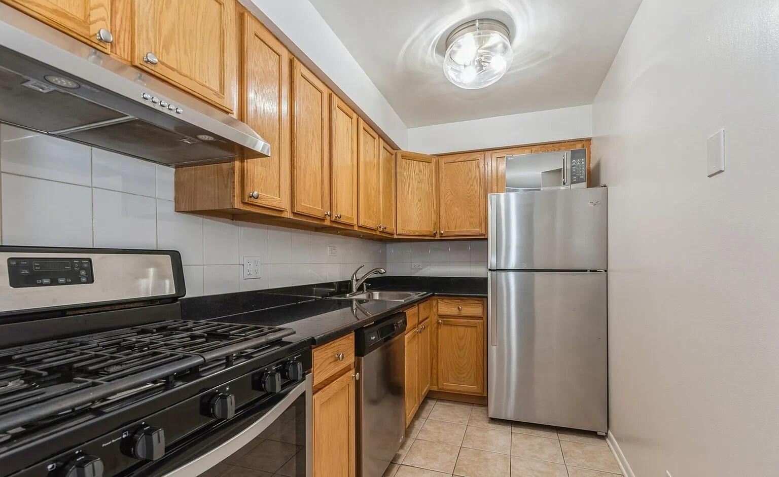 3900 North Pine Grove Avenue, Unit 405 Chicago, IL 60613 - Photo 12 of 15 a kitchen with a refrigerator and a stove top oven