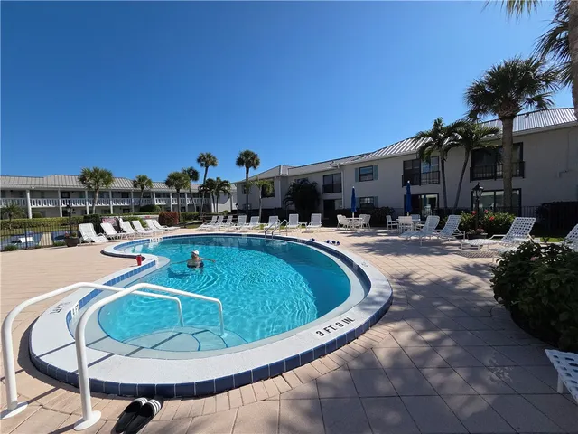 a view of a house with swimming pool and sitting area